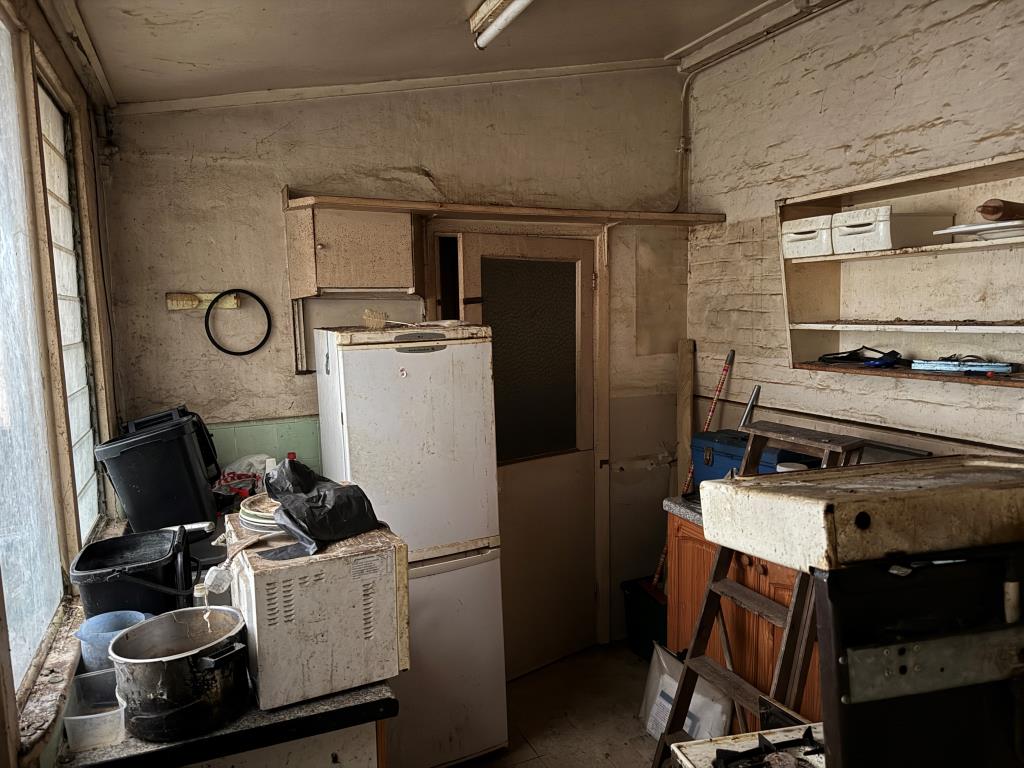 Lot: 168 - HOUSE IN NEED OF REFURBISHMENT - View of kitchen with door to bathroom & WC